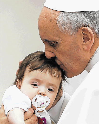 Pope Francis, blessing a baby at the Vatican yesterday, has slammed the loss of innocent life in the Bangladeshi factory fire