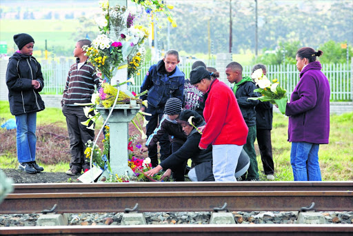 Family, friends and strangers pay their respects at the railway tracks in Blackheath , outside Cape Town. File picture