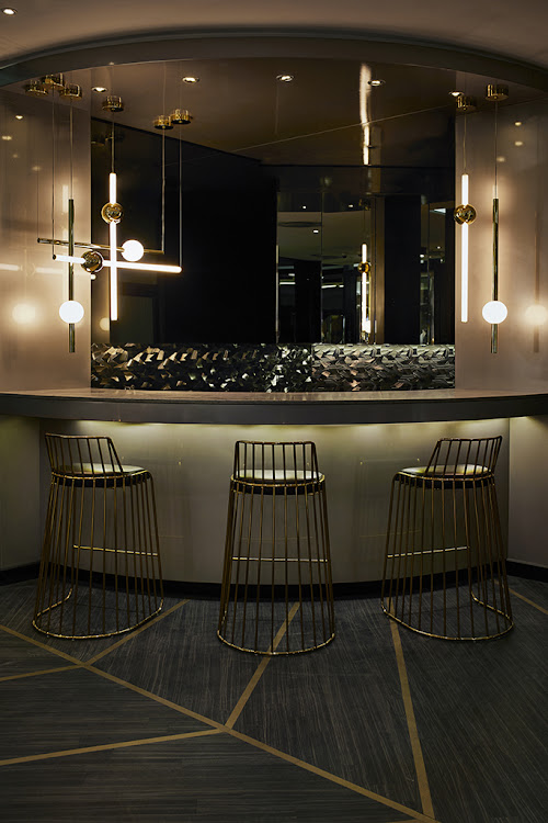 The bar with lighting by Lee Broom, stools from LA based Phase Design and the custom vinyl wall installation.