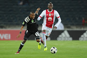 Orlando Pirates' defender Gladwin Shitolo (L) shields the ball away from Ajax Cape Town striker Tendai Ndoro (R) during the Nedbank Cup Last 32 match at Orlando Stadium on February 10, 2018 in Johannesburg, South Africa. 
