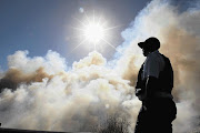 ENGULFED: A policeman looks at thick smoke that endangered motorists' visibility. File photo