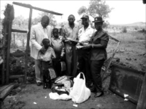 KIND: Businessman Moses Thembe, left, donates clothes and uniforms to orphans Mathimba and Musa Mothoki.18/02/09. Pic. Victor Hlungwani. © Sowetan.