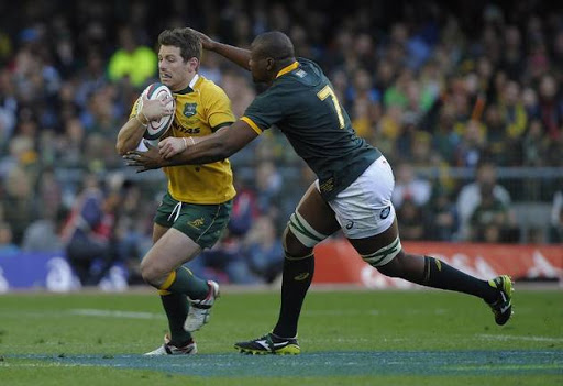Australian flyhalf Bernard Foley (L) is tackled by South African forward Teboho “Oupa” Mohoje during the Four Nations tournament rugby union match between South Africa and Australia at the Newlands stadium on September 27, 2014 in Cape Town.