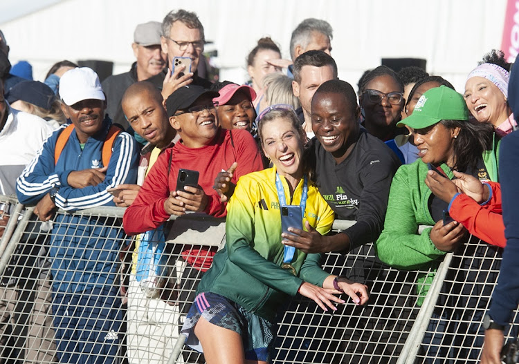 Gerda Steyn celebrates with spectators at the finish at UCT Rugby Fields after winning the 2023 Two Oceans Ultra Marathon in a new course record. Picture: PETER HEEGER/GALLO IMAGES
