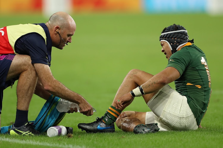 Cheslin Kolbe of South Africa receives treatment to his ankle during the Rugby World Cup 2019 Group B game between South Africa v Italy at Shizuoka Stadium Ecopa on October 04, 2019 in Fukuroi, Shizuoka, Japan.