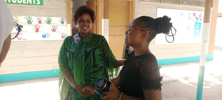 Garissa University Dean of students Dr Rozaline Mumo shares a light moment with Flora Njeri,a fourth year student at the institutions