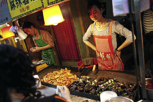 Cooks prepare street food in China.