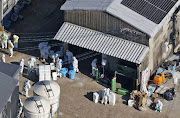 An aerial view shows officials wearing protective suits cull chickens at a poultry farm where officials detected highly pathogenic H5-type bird flu, in Kashima, Saga prefecture, Japan November 25, 2023, in this photo taken by Kyodo. 