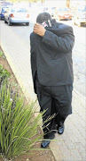 IN HIDING: A Uniting Reformed Church priest outside the Protea Glen police station yesterday after being arrested for theft and malicious damage to property. 
      PHOTO: SIBUSISO  MSIBI