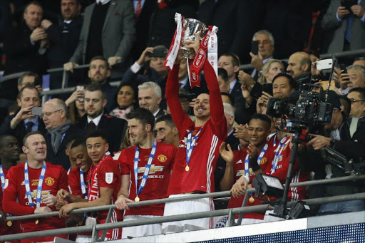 Man of the match, Manchester United's Swedish striker Zlatan Ibrahimovic lifts the trophy as Manchester United players celebrate their victory after the English League Cup final football match between Manchester United and Southampton at Wembley stadium in north London on February 26, 2017. Zlatan Ibrahimovic sealed the first major silverware of Jose Mourinho's Manchester United reign and broke Southampton's hearts as the Swedish star's late goal clinched a dramatic 3-2 victory in Sunday's League Cup final.