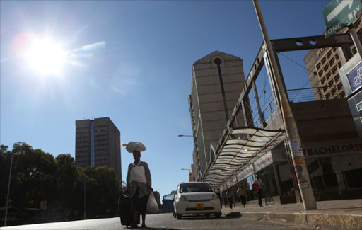 A woman walks along an empty street in the central business district of Harare, Zimbabwe, July 6, 2016. Image by: PHILIMON BULAWAYO / REUTERS