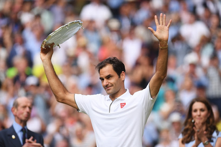 Roger Federer of Switzerland lifts his runners-up trophy following defeat in the Men's Singles final against Novak Djokovic of Serbia during Day thirteen of The Championships - Wimbledon 2019 at All England Lawn Tennis and Croquet Club on July 14, 2019 in London, England.