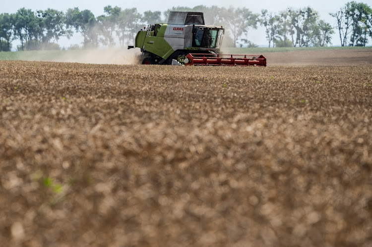 A combine harvests wheat in a field near the village of Tomylivka, as Russia's attack on Ukraine continues, in Kyiv region, Ukraine on August 1 2022. Picture: REUTERS/Viacheslav Ratynskyi