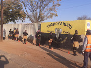 Masked grade 7 pupils at Thohoyandou Primary queue for their temperatures to be taken on their first day back at school.