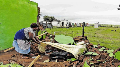 NOT MUCH LEFT: Residents of Toli Village in Dutywa lost most of their belongings during a storm that hit on Thursday afternoon. Their houses collapsed while others lost roofs. In this picture, Ntombende Vayeke tries to save what is left after the disaster Picture: SUPPLIED