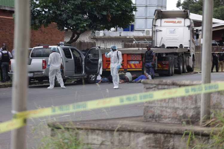 Police inspect the vehicles of five armed men suspected to be hitmen.