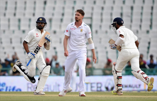 South Africa's Dale Steyn (C) looks on as India's Cheteshwar Pujara (R) and teammate Murali Vijay (L) run between the wickets during play on the first day of the first Test cricket match between India and South Africa at The Punjab Cricket Association Stadium in Mohali on November 5, 2015.