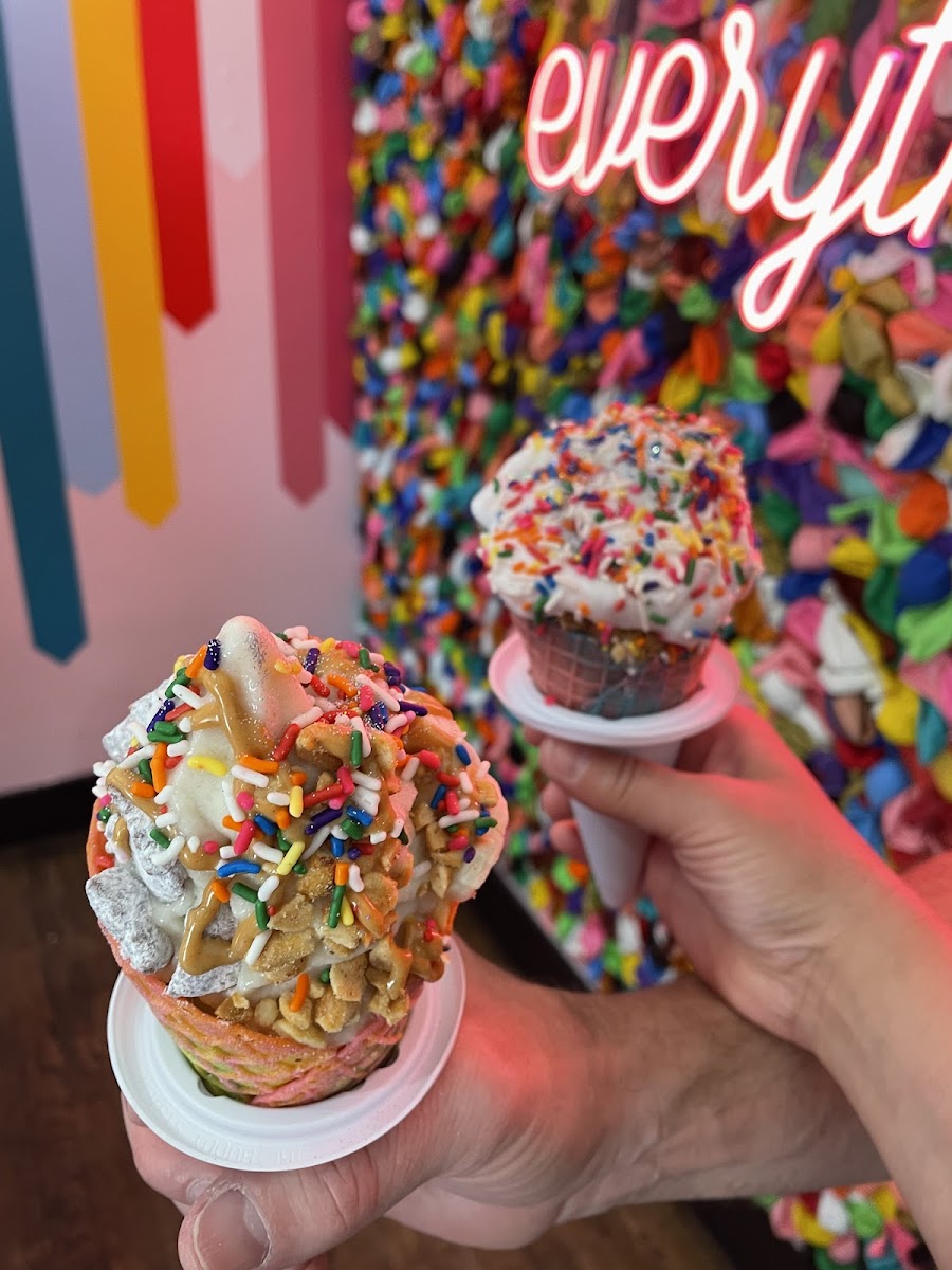 GF vegan cone with vanilla oat milk coconut flavored soft serve, puppy chow, coconut whip cream and sprinkles