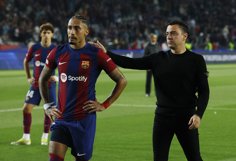 FC Barcelona's Raphinha and coach Xavi look dejected after their Champions League quarterfinal defeat against Paris St Germain after the second leg at Estadi Olimpic Lluis Companys in Barcelona on Tuesday.