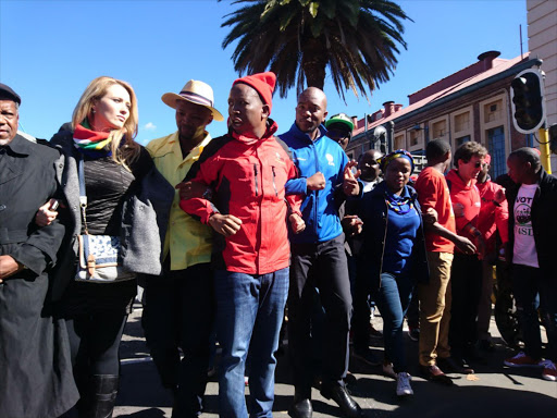 Opposition leaders including EFF's Julius Malema and DA's Mmusi Maimane lock arms as they march to the Constitutional Court where the secret ballot hearing is taking place on 15 May 2017.