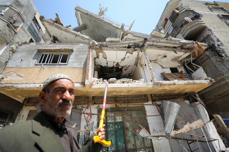 Palestinian man Ali Oroq, whose grandson Zein was wounded after he was hit by aid airdropped on Gaza and later succumbed to his wounds, points with a cane to their house which was hit in an Israeli strike, amid the ongoing conflict between Israel and the Palestinian Islamist group Hamas, in Gaza City on April 16 2024.
