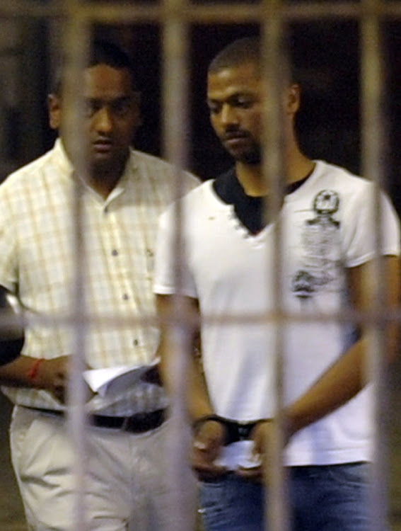 Detective W/O Shane Naidoo leads Thabo Bester out of the holding cells at the Durban magistrate's court on October 12 2011.