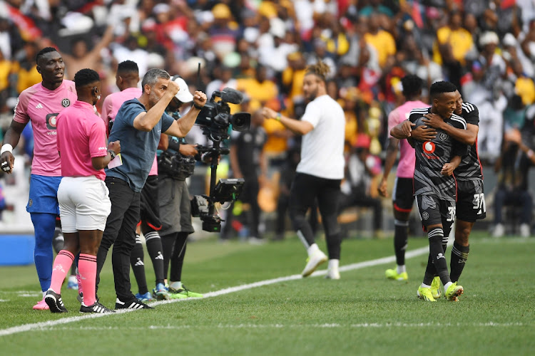 Orlando Pirates coach Jose Riveiro celebrates as Monnapule Saleng is congratulated on scoring by teammate Relebohile Mofokeng during the DStv Premiership Soweto derby against Kaizer Chiefs at FNB Stadium on Saturday.