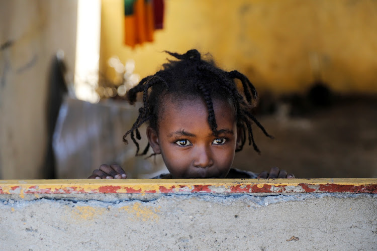 An Ethiopian girl stands at the window of a temporary shelter, at the Village 8 refugees transit camp, which houses Ethiopian refugees fleeing the fighting in the Tigray region, near the Sudan-Ethiopia border, Sudan, December 2, 2020.