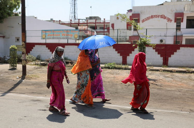 Women shelter under an umbrella due to the heat as they leave a polling station after casting their vote in Mathura, in the northern Indian state of Uttar Pradesh, India, on April 26 2024. Picture: REUTERS/ANUSHREE FADNAVIS/FILE