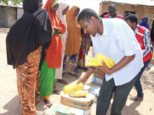 Lagdera sub county administrator Hud Rashid distributes assorted foodstuffs to families who were from Tana in Isiolo county following border clashes pitting the Boranas and Somalis./FILE