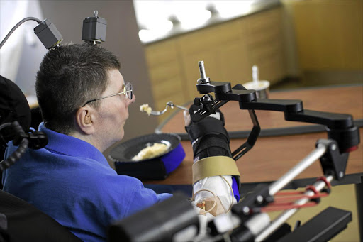 MIND YOUR TABLE MANNERS: Bill Kochevara, who was paralysed from the shoulders down in an accident eight years ago, can use his arms and hands again thanks to a computer interface that connects the severed link between his brain and his muscles