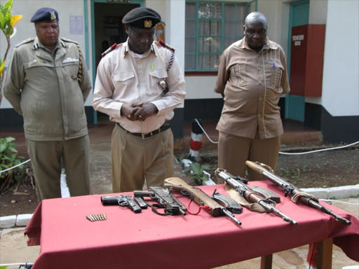 Migori county commissioner (C) Joseph Rotich with security officers from the county display surrendered to them in Migori town, Tuesday July 31, 2018. /MANUEL ODENY