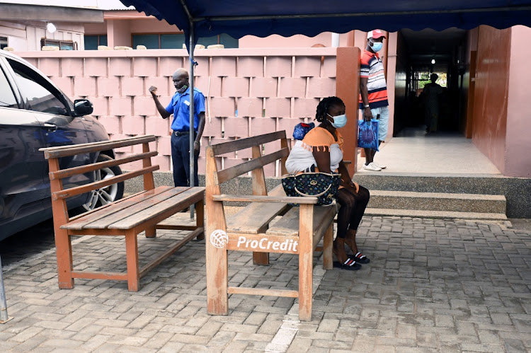 Empty benches are seen as a woman waits to be vaccinated against COVID-19 at the Mamprobi Polyclinic in Accra, Ghana on April 26, 2022.
