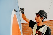 A painter works on one of the murals  on the school grounds.