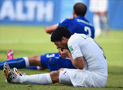 Luis Suarez of Uruguay and Giorgio Chiellini of Italy react after a clash during the 2014 FIFA World Cup Brazil Group D match between Italy and Uruguay at Estadio das Dunas.