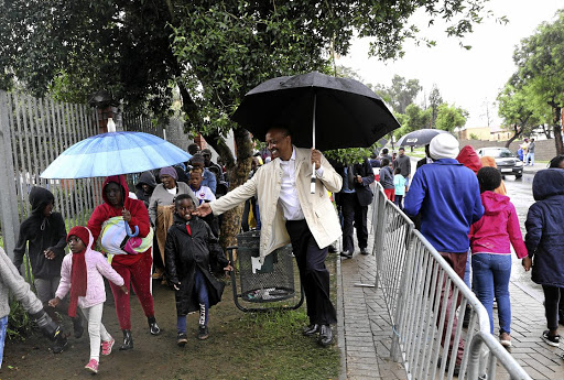 Patrice Motsepe cheers up kids in a long queue as they wait to receive their Christmas gifts at Orlando Stadium.