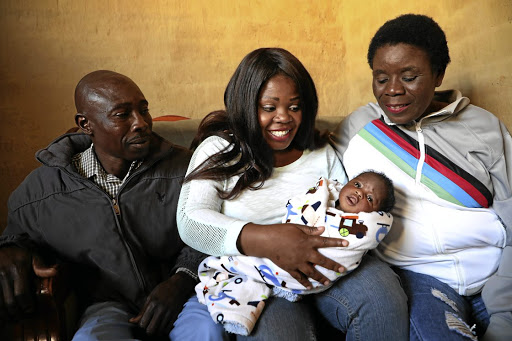 Sibongile Morudu holds Precious, whom she helped deliver a week ago, as parents Thomas Rakhavha and Elina Maseko look on.