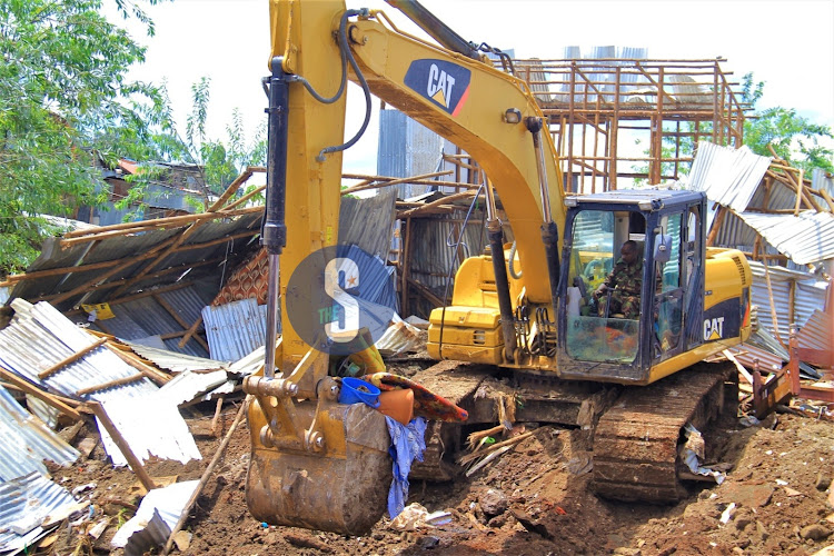 A KDF bulldozer demolishes structures along the Nairobi river bank in Kaimaiko area on May 3, 2024.