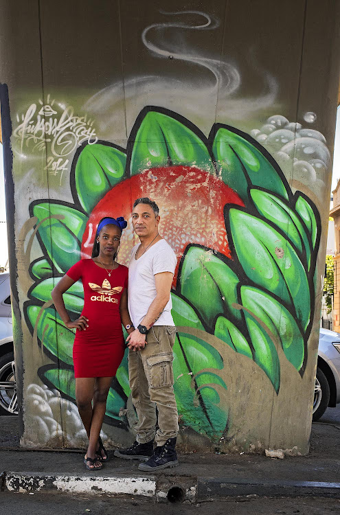 Lelo Mndaba and Volkan Eren on a stroll through Maboneng cultural precinct_ protea mural by FIYA City and Suburban 2018.