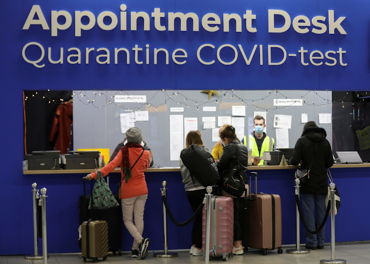 People wait in front of an "Appointment Desk" for quarantine and coronavirus disease test appointments inside Schiphol Airport, after Dutch health authorities said that 61 people who arrived in Amsterdam on flights from South Africa tested positive for Covid-19, in Amsterdam. File photo.