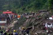 Rescue workers remove the debris as they search for survivors after a landslide following torrential rain in Shimla in the northern state of Himachal Pradesh, India, on August 14, 2023.