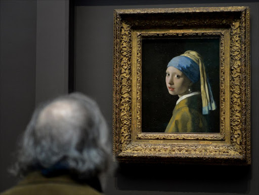 A man views "Girl with a Pearl Earring (c. 1665)" by Johannes Vermeer in the exhibition "Vermeer, Rembrandt, and Hals: Masterpieces of Dutch Painting from the Mauritshuis" October 21, 2013 at the Frick Collection in New York. The special exhibition is the final US venue of a global tour of paintings from the Royal Picture Gallery Mauritshuis in The Hague, the Netherlands and runs from October 22, 2013 to January 19, 2014.