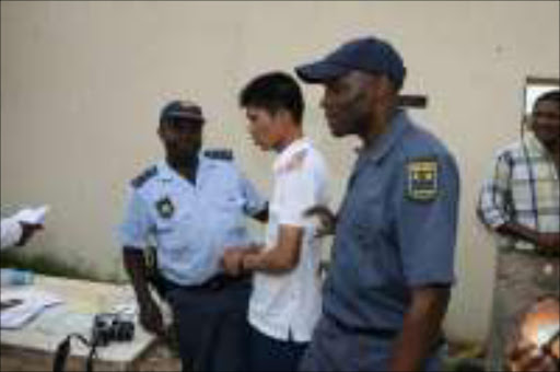 WALKING AWAY: Police from Operation Dudula during the raid on a house in Cyrildene, Johannesburg, where they confiscated DVDs, CEDs and computers. Zhouren Chen was arrested. Pic. Lucky Nxumalo. 03/04/07. © Sowetan.