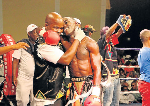 IN EYE OF STORM: Xolisani Ndongeni and his trainer Chief Njekanye embrace after Ndongeni beat Vusumzi Tyatyeka to win the R1-million at Orient Theatre a fortnight ago. ‘Nomeva’ is now caught between a rock and a hard place as Njekanye and promoter Ayanda Matiti clash over future plans Picture: SINO MAJANGAZA
