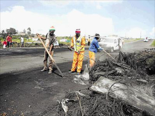 CLEAN UP: Municipal employees clean up the mess created by protestors in Lusikisiki