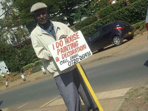 Painter Daniel Mung'ori displays his job search sign in Kilimani, Nairobi, January 13, 2018. /Courtesy