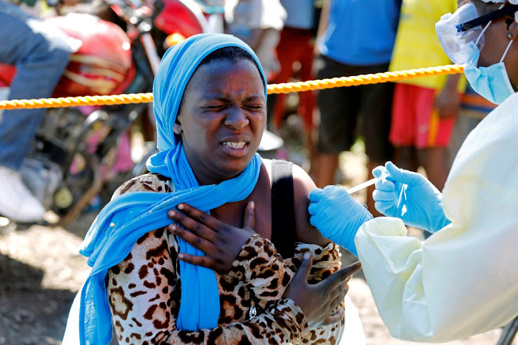 A young woman reacts as a health worker injects her with the Ebola vaccine, in Goma, Democratic Republic of Congo on August 5, 2019.