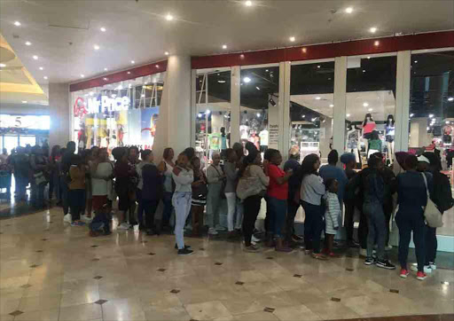 Shoppers hungry for a sweet deal wait for their merchandiser of choice to open at Canal Walk shopping mall in Cape Town. Image: Esa Alexander )