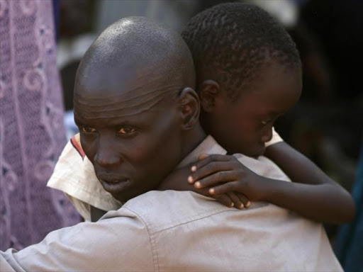 An internally displaced man holds his son inside a United Nations Missions in Sudan (UNMIS) compound in Juba December 19, 2013. Photo/REUTERS