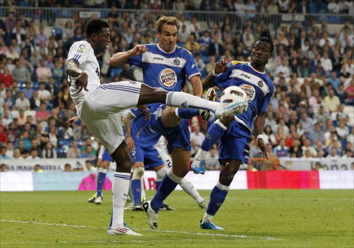 Emmanuel Adebayor of Real Madrid fights for the ball with Borja Fernandez (C) and Derek Boateng of Getafe during the La Liga match between Real Madrid and Getafe at Estadio Santiago Bernabeu on May 10, 2011 in Madrid, Spain